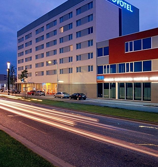 "a large hotel building with a blue sign and the word "" hotel "" on the side" at Novotel Leuven Centrum