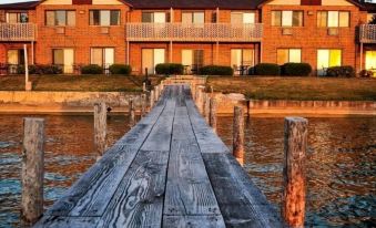 a wooden dock extending into a body of water , with a row of buildings in the background at Lakeside Inn