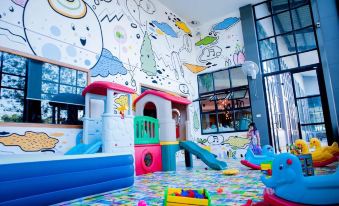 a colorful playroom with a variety of toys , including a slide , for children to enjoy at Suanpa Resort