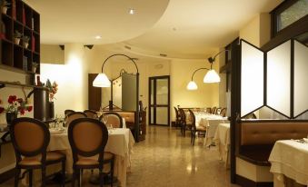a large dining room with multiple tables and chairs arranged for a group of people to enjoy a meal together at Hotel Moderno