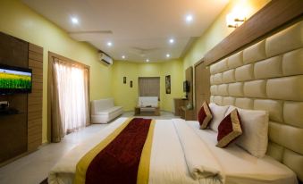 a large bed with a maroon and gold blanket is in the middle of a room with yellow walls at The River Front Resort
