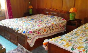 a bedroom with two beds , one on the left and one on the right , both covered with colorful blankets at Dawn
