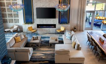a modern living room with a large flat - screen tv mounted on the wall , surrounded by comfortable couches and chairs at Fenwick Shores, Tapestry Collection by Hilton
