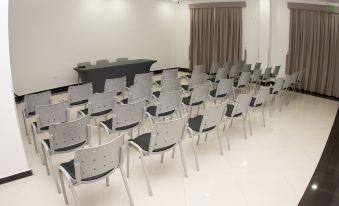 a conference room with rows of chairs arranged in a semicircle , and a podium at the front at Nova Hotel