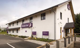 "a white building with a purple sign that says "" premier inn "" and a wooden fence in front" at Premier Inn Tamworth South