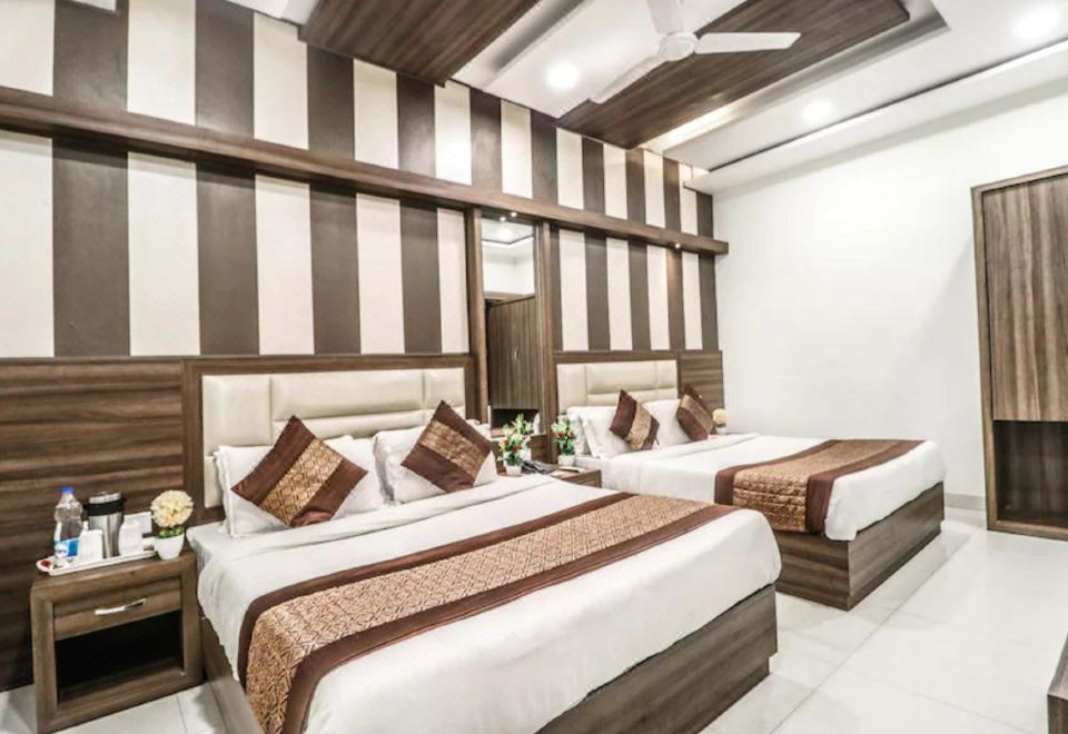 a modern hotel room with two beds , a wooden headboard , and white walls decorated with brown stripes at Hotel Kings