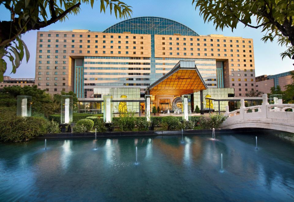 A building with two large glass facades in the front and one on the other side at Kempinski Hotel Beijing Yansha Center