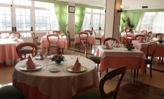 a well - decorated dining room with several tables and chairs , all set for a meal at Pousada de Portomarin