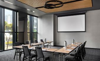 a conference room with wooden ceiling , large windows , and multiple tables set up for a meeting at Vibe Hotel Melbourne Docklands