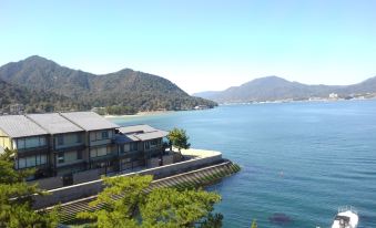 a picturesque view of a house situated on the edge of a cliff , overlooking a body of water at Sakuraya