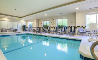 an indoor swimming pool with a large number of lounge chairs surrounding it , creating a relaxing atmosphere at Hilton Garden Inn Nanuet