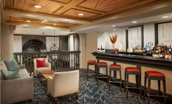 a cozy living room with wooden ceiling , white walls , and wooden furniture , including a bar area at The Terrace Hotel Lakeland, Tapestry Collection by Hilton