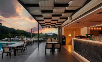 a modern restaurant with a bar and outdoor seating area , overlooking a beautiful sunset view at Altamar Hotel