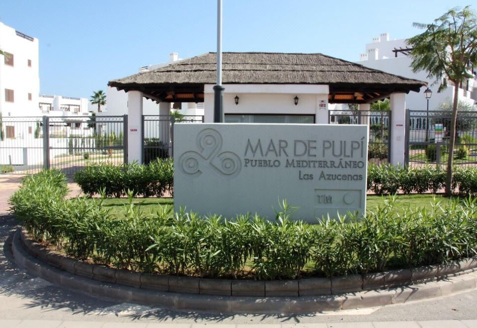a sign for mar de púpello , a building with a thatched roof and plants in front at Casa Blanca