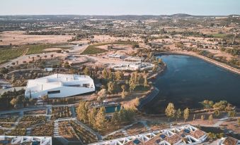 aerial view of a city with buildings , trees , and a lake in the middle of it at L'And Vineyards