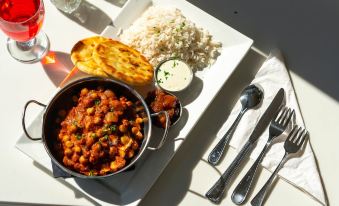 a table is set with a variety of dishes , including a bowl of chickpeas and a plate of rice at Auberge Gisele's Inn