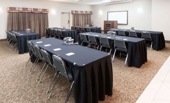 a conference room set up for a meeting , with several chairs arranged in rows and a projector mounted on the wall at Ramada by Wyndham High River