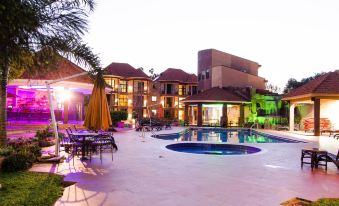 a large villa with a pool and lounge chairs is surrounded by palm trees and lit up at night at Nile Village Hotel & Spa