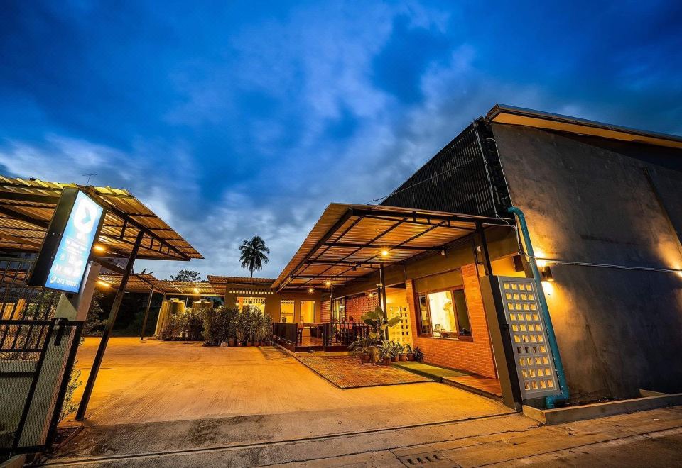 a building with a large awning over the front entrance , illuminating the area at night at The Sekret Hotel