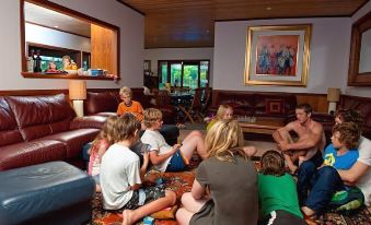 a group of children are gathered in a living room , playing video games and enjoying each other 's company at Bilpin Country Lodge