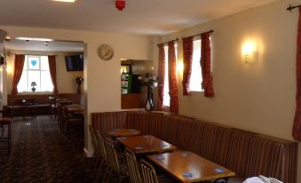 a dining room with several tables and chairs arranged for a group of people to enjoy a meal together at The Shoes