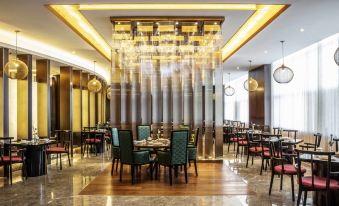 a large dining room with multiple tables and chairs arranged for a group of people to enjoy a meal together at Pullman Changbaishan Resort