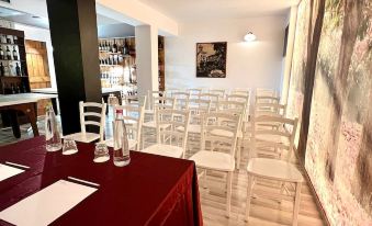 a conference room with a red table and white chairs , set up for an event at Hotel Joli