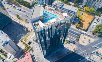 aerial view of a tall building with a swimming pool , surrounded by other buildings and a highway at Icon Hotel