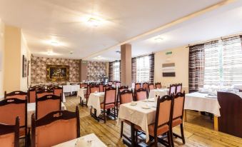 a large dining room with multiple tables and chairs arranged for a group of people to enjoy a meal together at Roseview Alexandra Palace Hotel