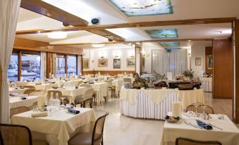 a large dining room with numerous tables and chairs arranged for a group of people to enjoy a meal together at Hotel L'Approdo