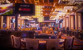 a large , well - lit casino with multiple rows of tables and chairs arranged in an open space at Soboba Casino Resort