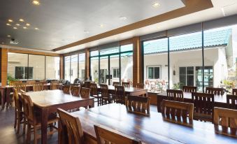 a large dining room with wooden tables and chairs arranged for a group of people at Baan Tah on the Sea