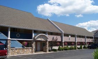 a large building with a curved roof and several columns is surrounded by a parking lot at Pinestead Reef Resort