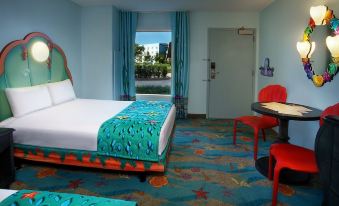 a modern hotel room with a bed , desk , and red chairs , all set against a blue wall at Disney's Art of Animation Resort