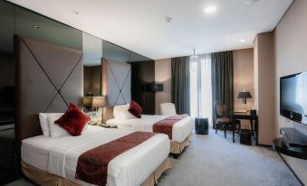 a modern hotel room with two beds , one on the left and one on the right side of the room at Amaroossa Hotel Bandung Indonesia