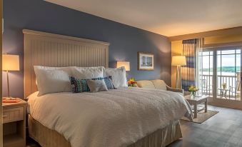 a large bed with white linens and multiple pillows is in a bedroom with blue walls at Chautauqua Harbor Hotel - Jamestown