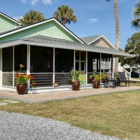 Family getaway with screened-in porch steps from surf and sun!