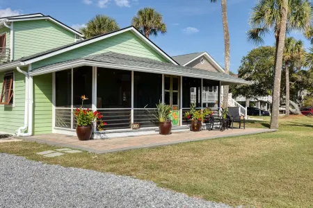 Family getaway with screened-in porch steps from surf and sun!