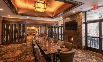 a large dining room with a long table , multiple chairs , and a fireplace in the background at The Craftsman Inn & Suites