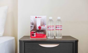 "a hotel room with two bottles of water and a bed , along with a "" red cart "" sign on the nightstand" at RedDoorz @ Beringin Jambi