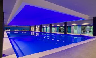 a large , empty indoor swimming pool with blue lighting and a ceiling that is covered in artificial lights at Park Plaza Belvedere Medulin
