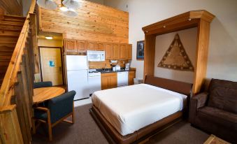 a hotel room with a wooden theme , including a bed , kitchenette , and dining area , along with other amenities at The Inn at Silvercreek