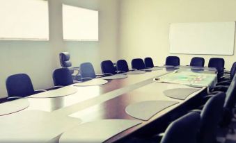 a large conference room with a long table , chairs , and a whiteboard , set up for a meeting at Grand Palace Hotel Mzuzu