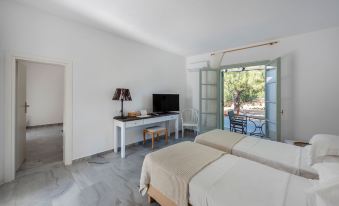 a modern bedroom with a bed , desk , and tv , as well as an open window leading to a patio at Parosland Hotel