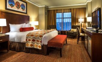 a well - appointed hotel room with a king - sized bed , a desk , and a chair in the corner at Four Winds Casino Resort – New Buffalo