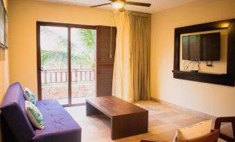a living room with a couch , coffee table , and sliding glass doors leading to a balcony at Villas Grand Marina Kinuh