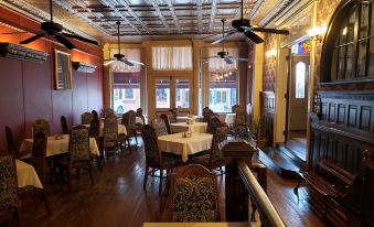 a dining room with wooden tables and chairs arranged for a group of people to enjoy a meal together at Iron Horse Hotel