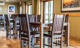 a dining room with wooden chairs and tables , creating a warm and inviting atmosphere for guests at Yellowstone Valley Lodge, Ascend Hotel Collection