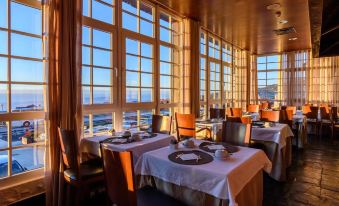 a large dining room with several tables and chairs arranged for a group of people to enjoy a meal at Luna Hotel Serra da Estrela