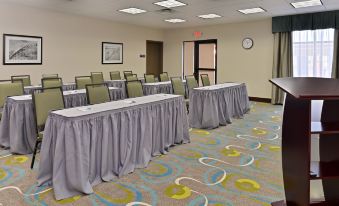 a conference room set up for a meeting , with tables and chairs arranged in rows at Homewood Suites by Hilton Houma